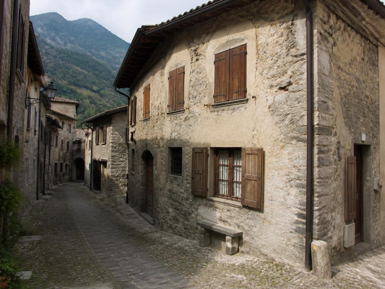 Casa in pietra con persiane in legno lungo un vicolo di un borgo dei Monti Sibillini